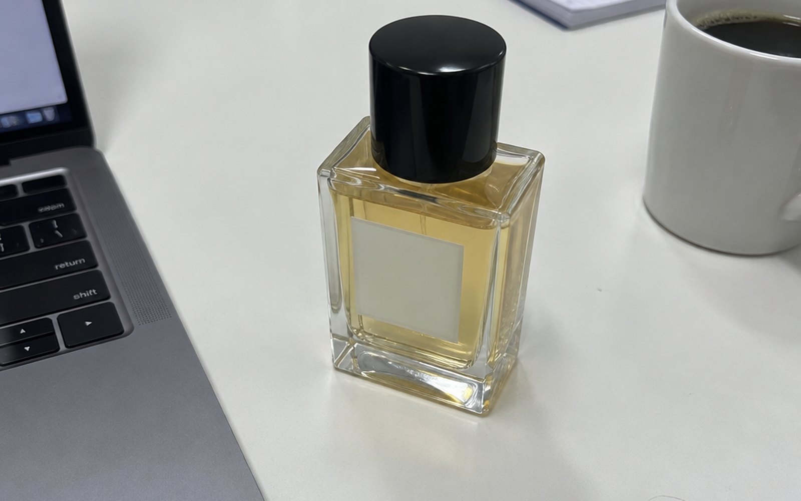 Flacone di profumo fotografato col telefono sulla scrivania