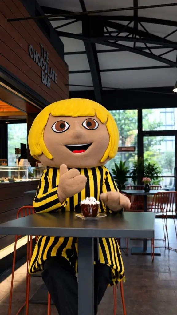 La mascotte di Eurochocolate al tavolino con una cioccolata calda